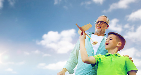 Image showing senior man and boy with toy airplane over sky