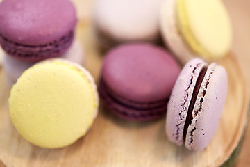 Image showing close up of different macarons on wooden stand