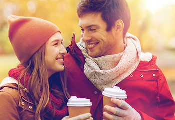 Image showing happy couple with coffee walking in autumn park