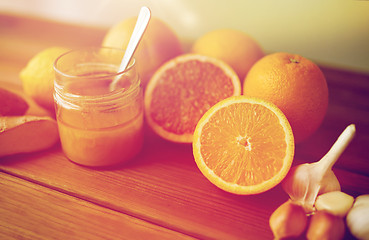 Image showing honey, citrus fruits, ginger and garlic on wood