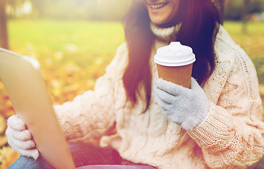 Image showing woman with tablet pc and coffee cup in autumn park