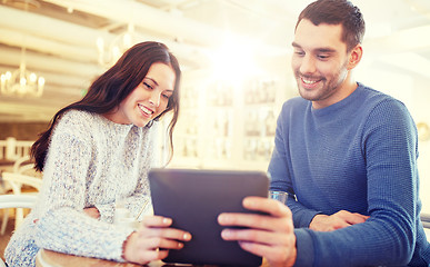 Image showing happy couple with tablet pc drinking tea at cafe