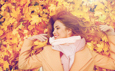 Image showing beautiful happy woman lying on autumn leaves