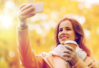 Image showing woman taking selfie by smartphone in autumn park