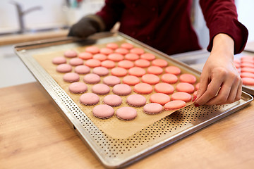 Image showing chef with macarons on oven tray at confectionery