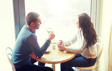 Image showing happy couple drinking tea and coffee at cafe