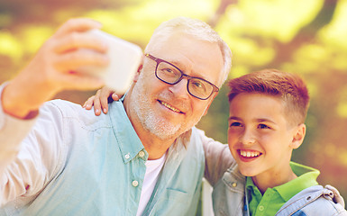 Image showing old man and boy taking selfie by smartphone