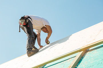 Image showing Builder at work with wooden roof construction.