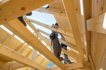 Image showing Builders at work with wooden roof construction.