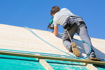 Image showing Builder at work with wooden roof construction.