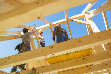 Image showing Builders at work with wooden roof construction.