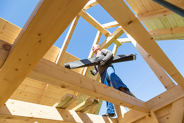 Image showing Builder at work with wooden roof construction.