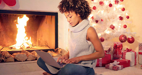 Image showing Chic young woman typing a Christmas message