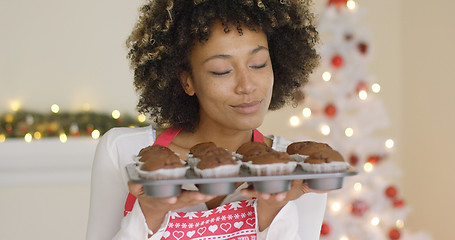 Image showing Smiling happy woman with tray of fresh muffins