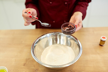 Image showing chef hands adding food color into bowl with flour