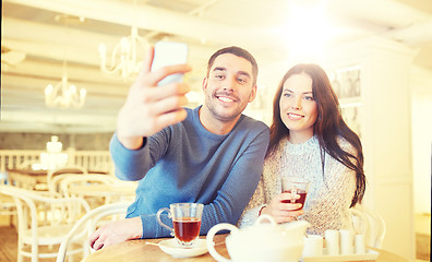 Image showing couple taking smartphone selfie at cafe restaurant