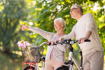 Image showing happy senior couple with bicycles at summer park