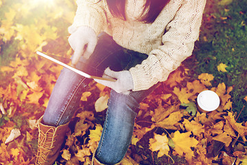 Image showing woman with tablet pc and coffee in autumn park