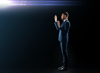 Image showing businessman in suit touching something invisible