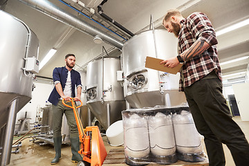 Image showing men with beer kegs and clipboard at craft brewery