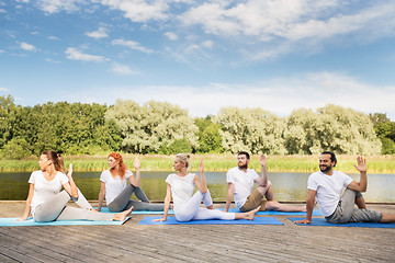 Image showing people making yoga in half lord of the fishes pose