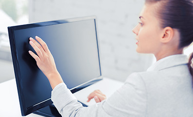 Image showing smiling businesswoman with touchscreen in office