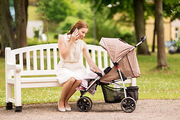 Image showing happy mother with smartphone and stroller at park