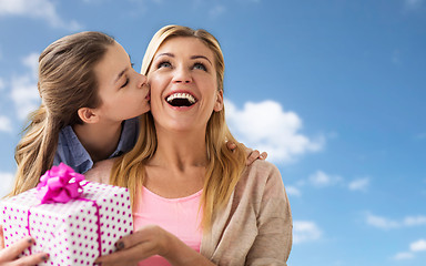 Image showing girl giving birthday present to mother over sky