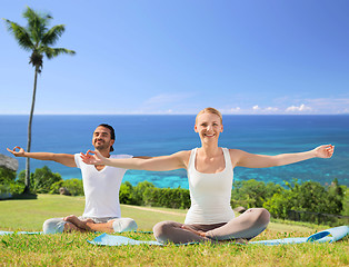 Image showing couple doing yoga in lotus pose outdoors