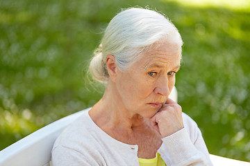 Image showing sad senior woman sitting on bench at summer park