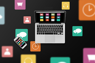 Image showing laptop computer with menu icons and smartphone