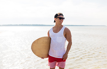 Image showing happy young man with skimboard on summer beach