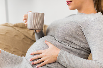 Image showing happy pregnant woman with cup drinking tea at home