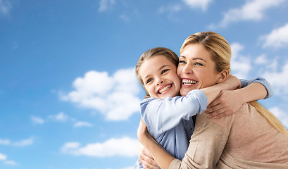 Image showing happy family of girl and mother hugging over sky