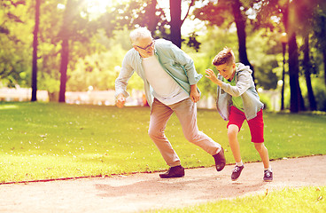 Image showing grandfather and grandson racing at summer park