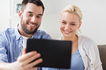 Image showing smiling happy couple with tablet pc at home