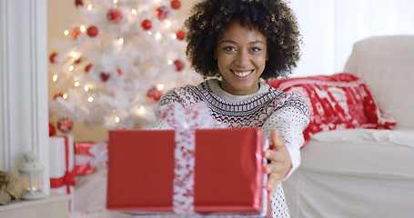 Image showing Smiling friendly woman offering a Christmas gift