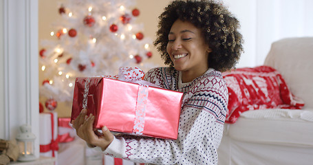 Image showing Happy young woman holding a Christmas gift