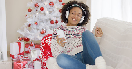 Image showing Young girl relaxing listening to Christmas music