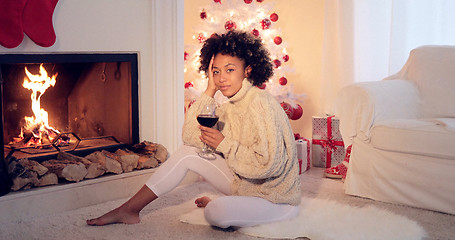 Image showing Woman in leggings and sweater sits by white tree