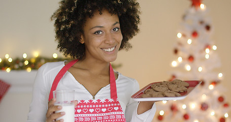 Image showing Happy young woman with milk and cookies for Santa