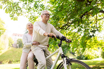 Image showing happy senior couple riding on bicycle at park