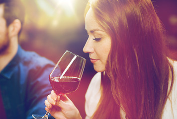 Image showing smiling woman drinking red wine at restaurant