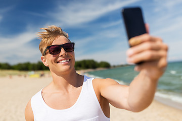 Image showing man with smartphone taking selfie on summer beach