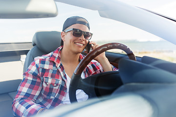 Image showing happy man calling on smartphone in convertible car