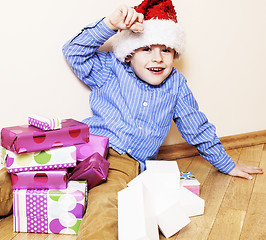 Image showing little cute boy with Christmas gifts at home. close up emotional