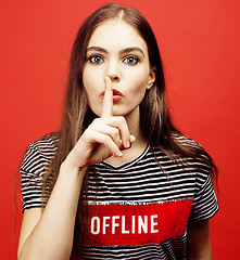 Image showing young pretty emitonal posing teenage girl on bright red background, happy smiling lifestyle people concept 