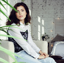 Image showing young pretty brunette woman in her bedroom sitting at window, happy smiling lifestyle people concept