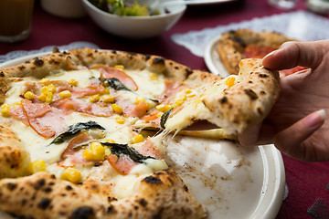 Image showing Hand taking out sliced of pizza