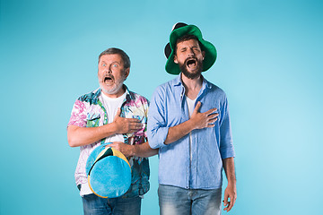 Image showing The two football fans singing the national anthem over blue